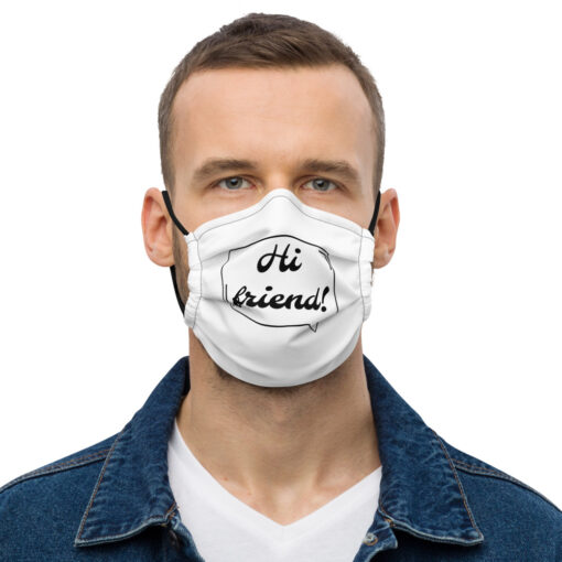 a person wearing a white face covering featuring the phrase "Hi friend!" in black