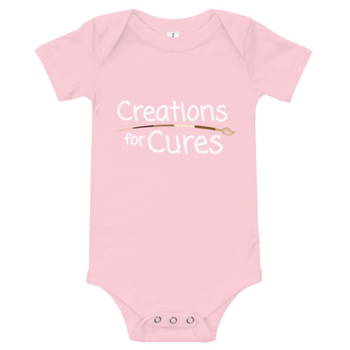 a pink short-sleeve baby one-piece featuring the Creations for Cures with diverse skin tone paintbrush