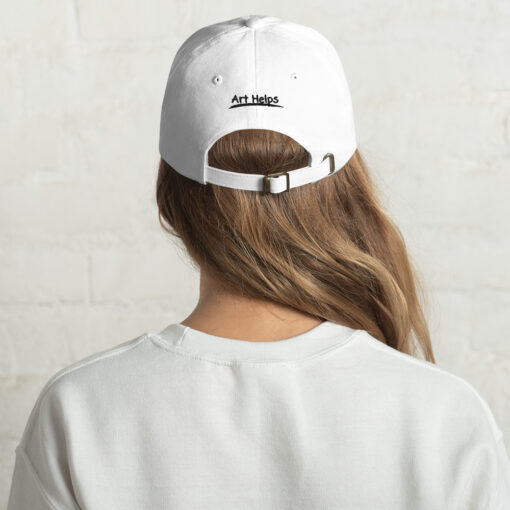 back view of a person wearing a white "dad" hat featuring the phrase "Art Helps" in black above the adjustment strap