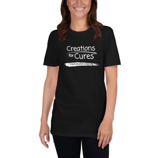 a person wearing a black t-shirt featuring the Creations for Cures logo in white