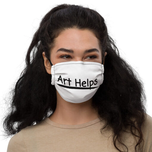 a person wearing a white face covering featuring the phrase "Art Helps" in black
