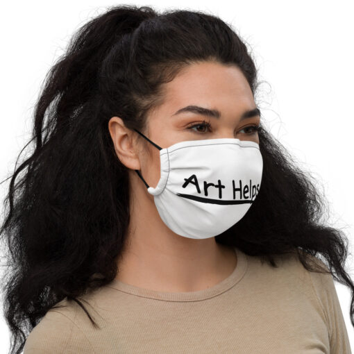 a person wearing a white face covering featuring the phrase "Art Helps" in black