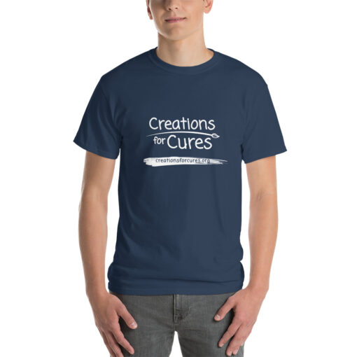 a person wearing a dusk blue t-shirt featuring the Creations for Cures logo in white
