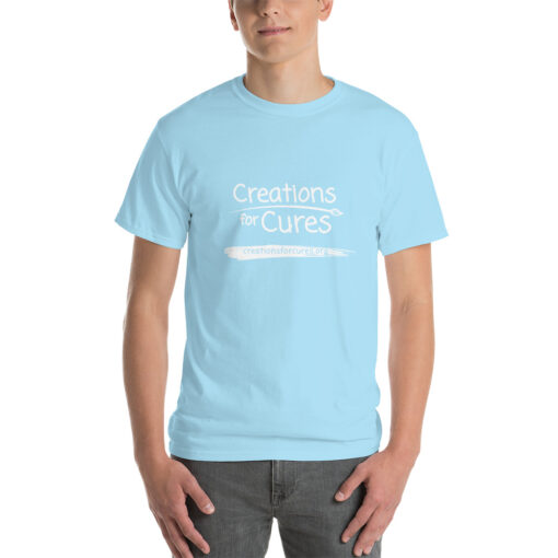 a person wearing a sky blue t-shirt featuring the Creations for Cures logo in white