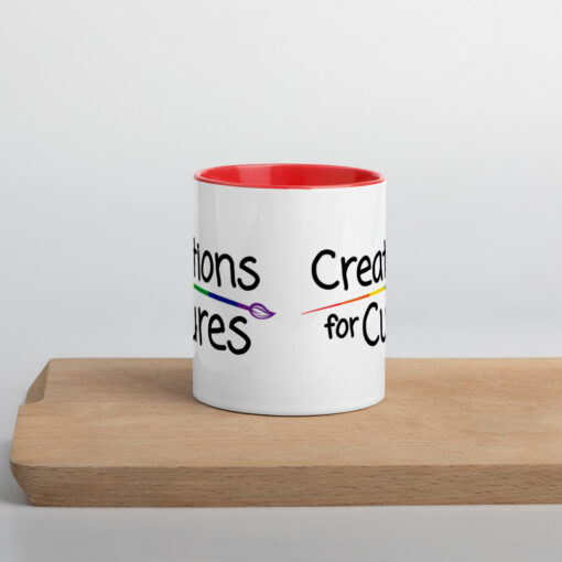 a white ceramic mug with red handle and interior featuring the Creations for Cures logo