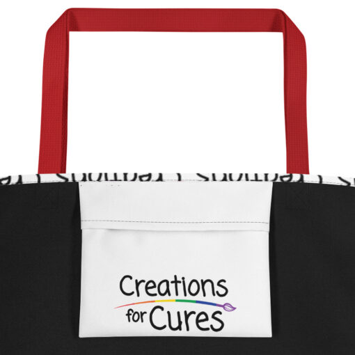 a large tote bag with interior pocket and red straps that features the Creations for Cures logo