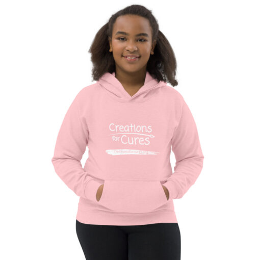 a person wearing a kids size pink hoodie featuring the Creations for Cures logo