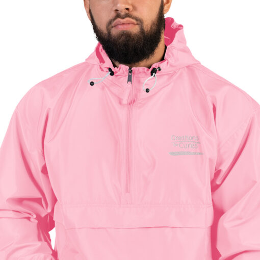 a person wearing a pink Champion pullover jacket with the Creations for Cures logo on it