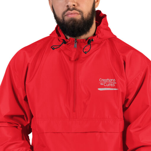 a person wearing a scarlet red Champion pullover jacket with the Creations for Cures logo on it